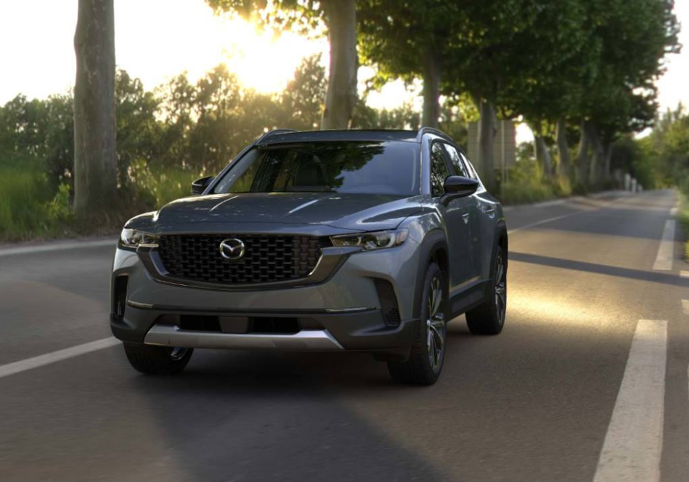 Mazda CX-50 driving down an empty road