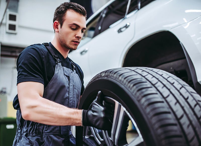 A service expert install a tire on a car